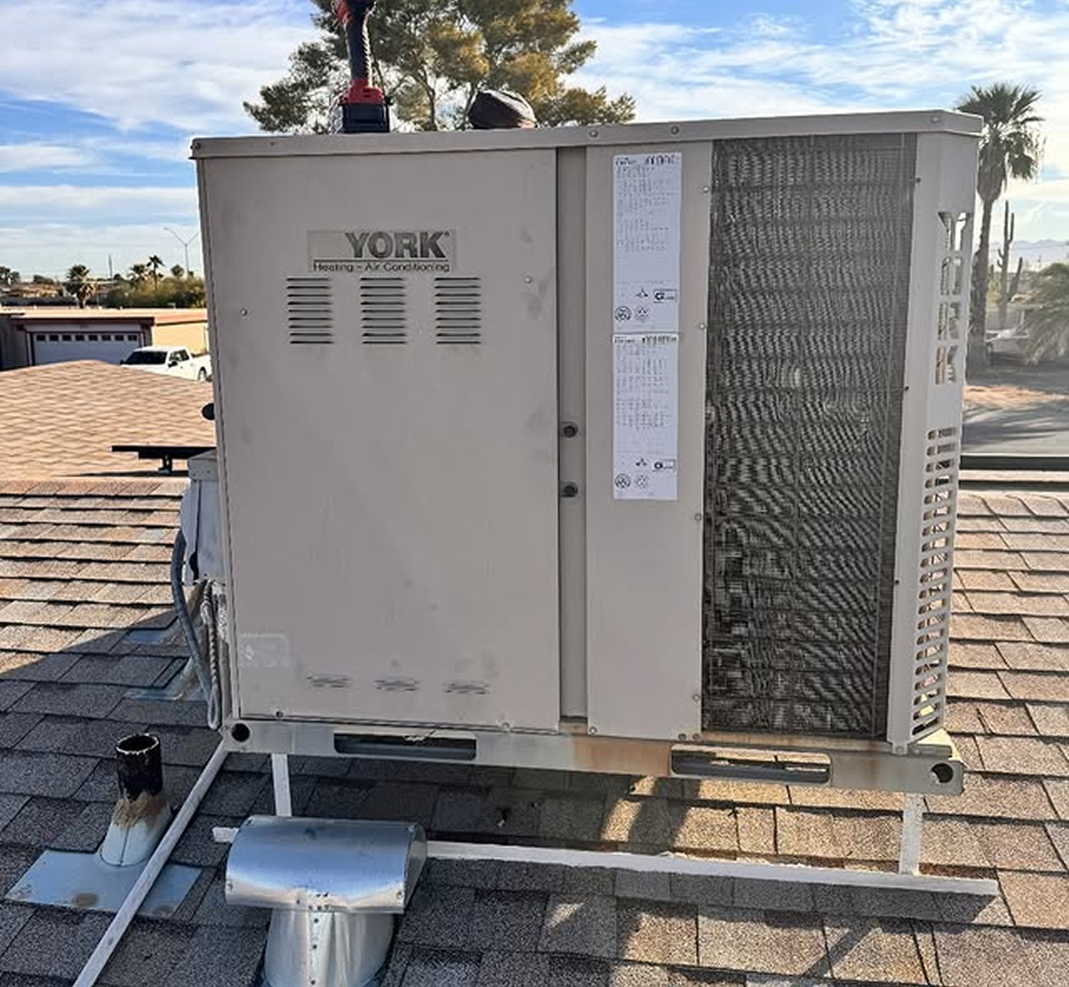 Rooftop air conditioning unit under blue sky.