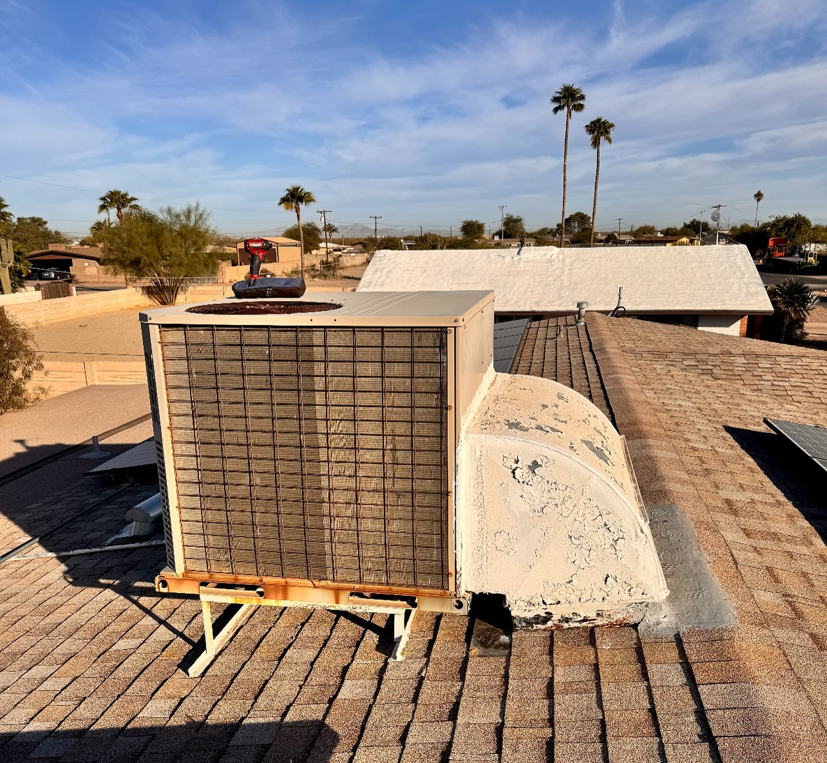 Rooftop air conditioning unit under clear sky.